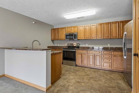 A kitchen with wooden cabinets and a granite countertop.