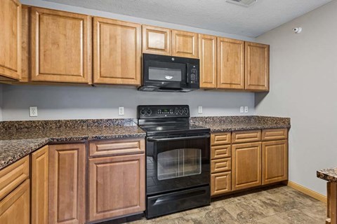 A kitchen with wooden cabinets and a black oven.