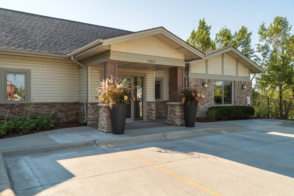 the front entrance of a house with a driveway and a porch