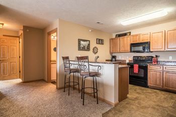 a kitchen with a bar with three stools