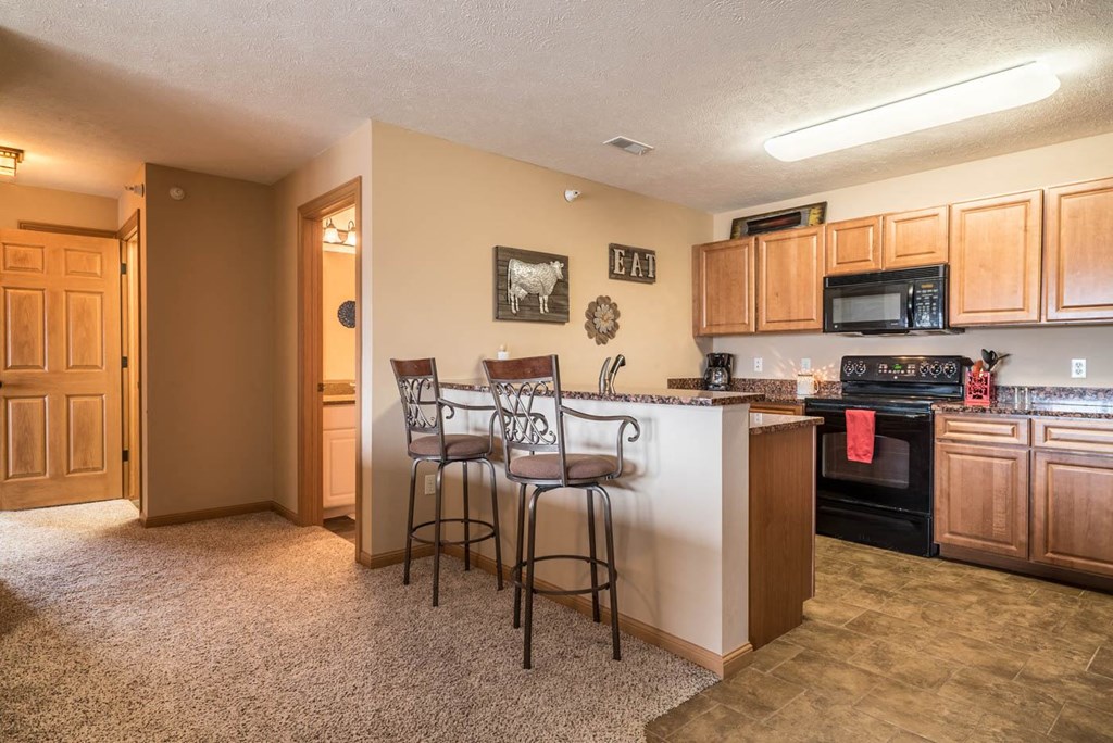 a kitchen with a bar with two stools