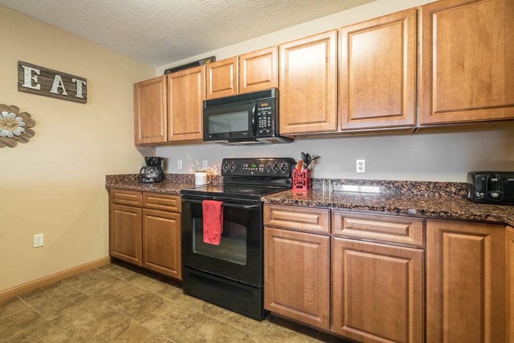 a kitchen with black appliances and wooden cabinets