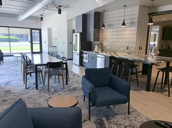 community room with lounge seating and kitchen at Haven at Uptown in Lincoln, NE