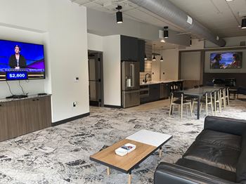 community room with lounge areas, TVs, and kitchen for entertaining