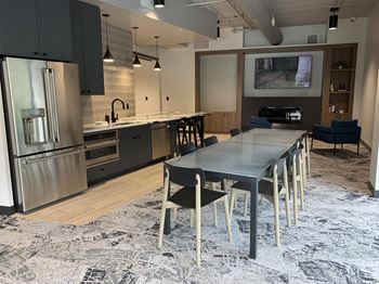 community room with lounge areas, TVs, and kitchen for entertaining