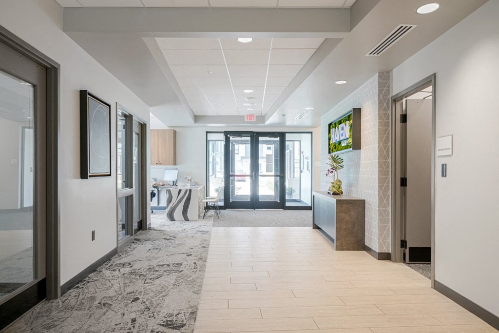 a long hallway with glass doors and a reception desk