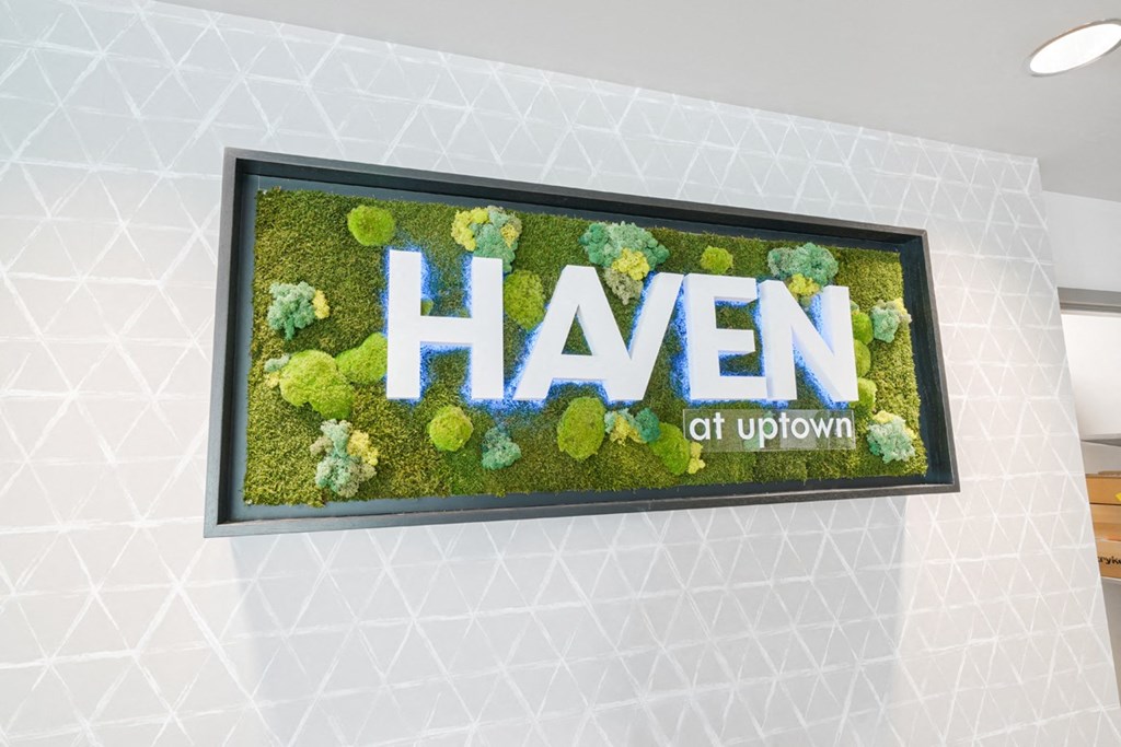 a sign for the haven of uptown is displayed in the lobby of a building