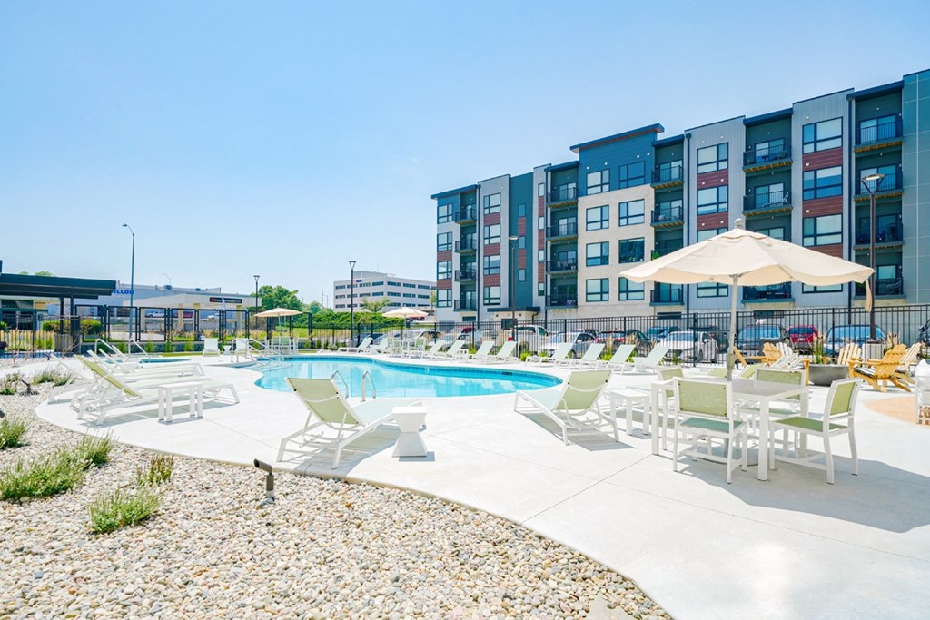 a view of the courtyard with the pool and lounge seating in front of the Haven at Uptown apartments