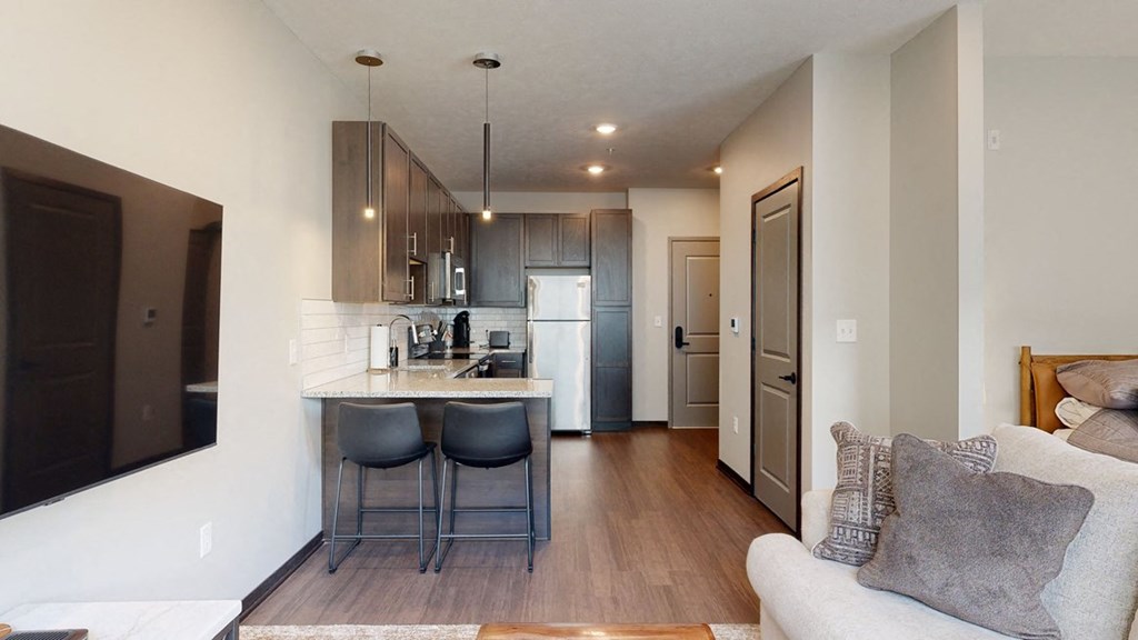 a kitchen a with two bar stools at the counter