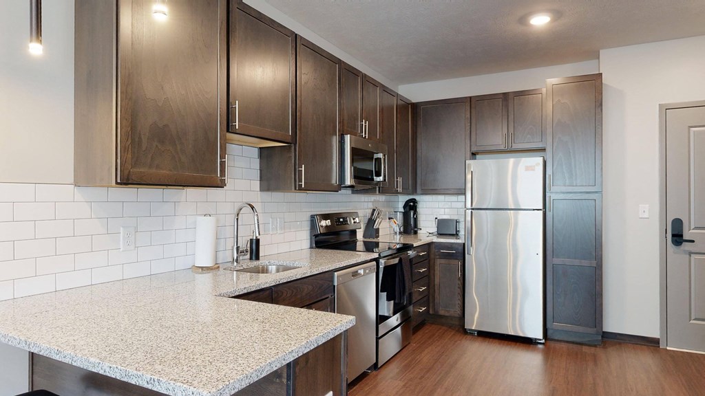 a kitchen with dark wood cabinets and white granite countertops