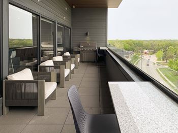 the sky deck with a grill and chairs over looking the city of lincoln