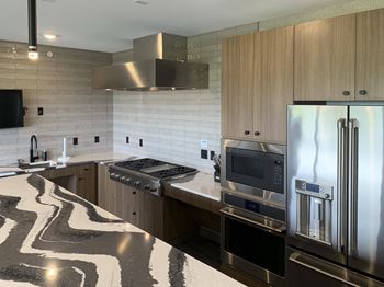 The kitchen in the sky lounge with large island and stainless steel appliances
