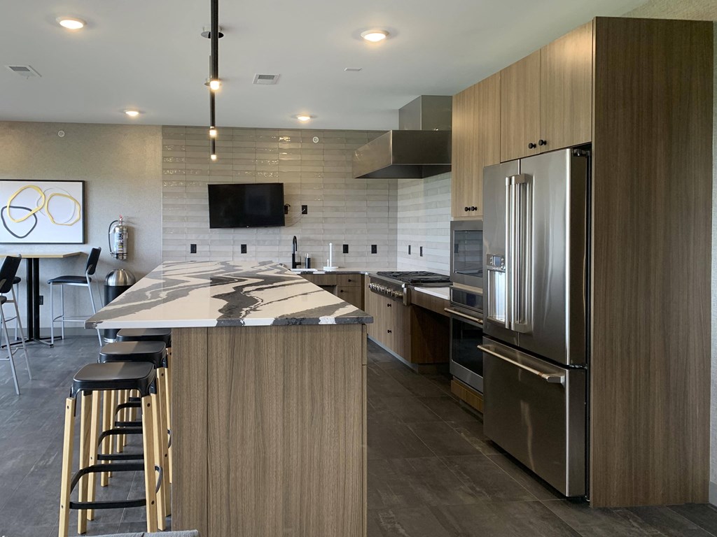 a kitchen in the sky lounge with a large island and stainless steel appliances