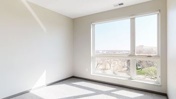 Large windows providing abundant natural light in the bedroom of the Bliss floor plan at Haven at Uptown in Lincoln, NE