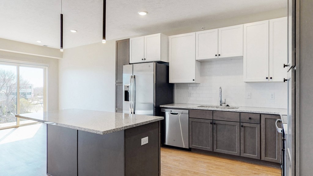 Beautiful kitchen completed with two tone slate finishes, including pendant lighting and stainless steel appliances in the Bliss floor plan at Haven at Uptown in Lincoln, NE