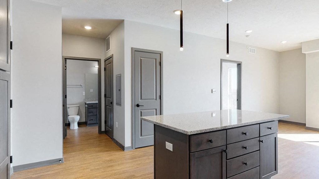 View of kitchen island and hallway leading to the bathroom in the Bliss floor plan at Haven at Uptown in Lincoln, NE