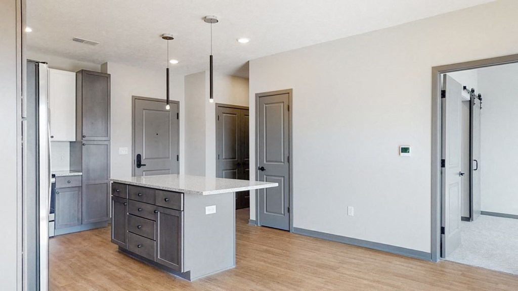 Pendant lighting and island providing seating in the Bliss floor plan kitchen at Haven at Uptown in Lincoln, NE