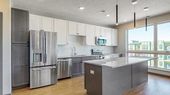 Melody (1 bed, 1 bath) in Slate finish Large windows filter abundant natural light into the spacious kitchen in the Melody floor plan at Haven at Uptown in Lincoln, NE - Photo Gallery 2