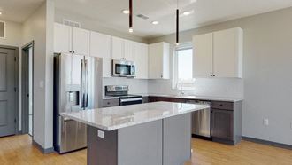 Shine (2 bed, 2 bath) in Slate finish Kitchen and island seating with the slate finish style in the Shine floor plan at Haven at Uptown in Lincoln, NE