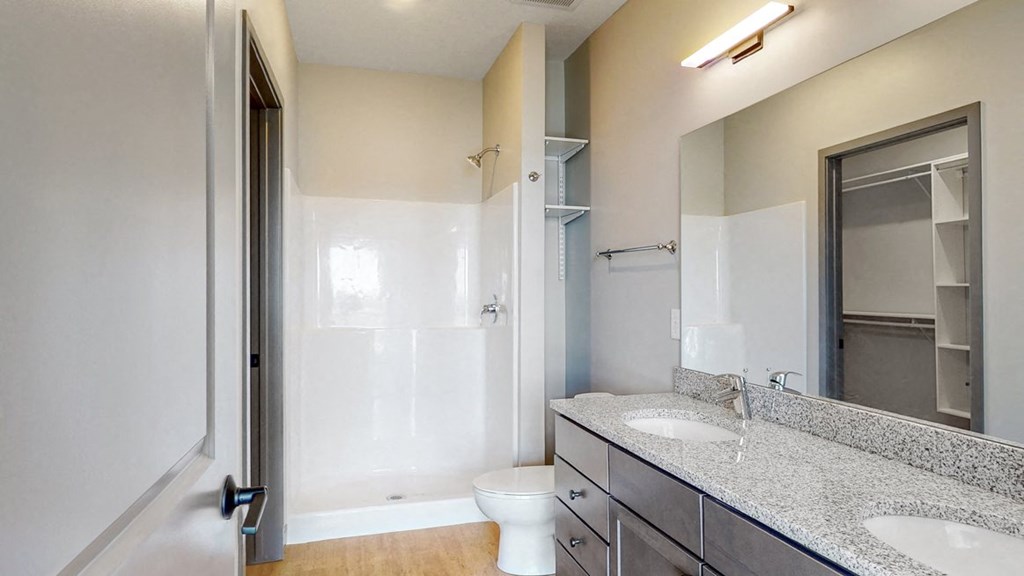 View of dual sink counter tops and shower in bathroom attached to the master bedroom at Haven at Uptown in Lincoln, NE