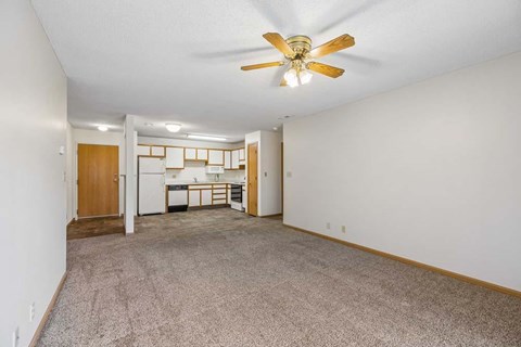 A room with a ceiling fan and carpeted floor.