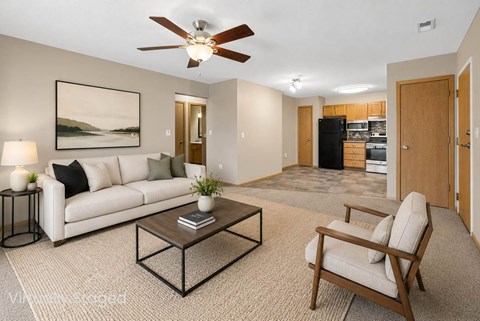 A living room with a white couch, a coffee table, and a ceiling fan.