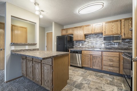 A kitchen with wooden cabinets and a granite countertop.