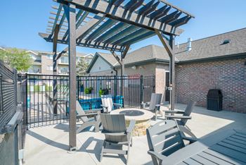 a poolside lounge space with Adirondack chairs sounding a fire pit under a pergola