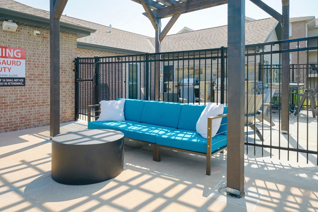 a lounging couch and table next to the pool