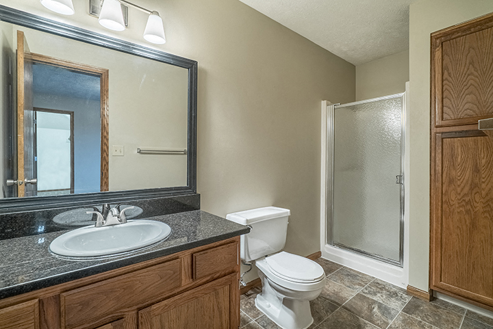 Full bathroom with shower and plenty of storage space at Fountain Glen Apartments