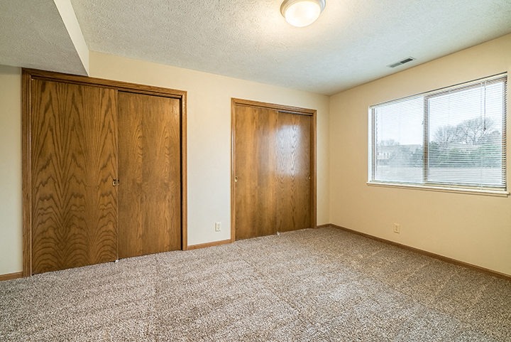 Bedroom with two closets providing plenty of storage space at Fountain Glen Apartments