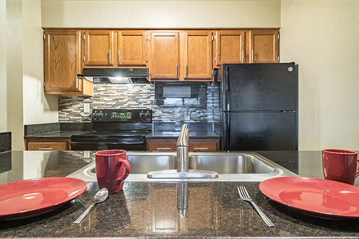View of kitchen from the seating at a breakfast bar at Fountain Glen Apartments