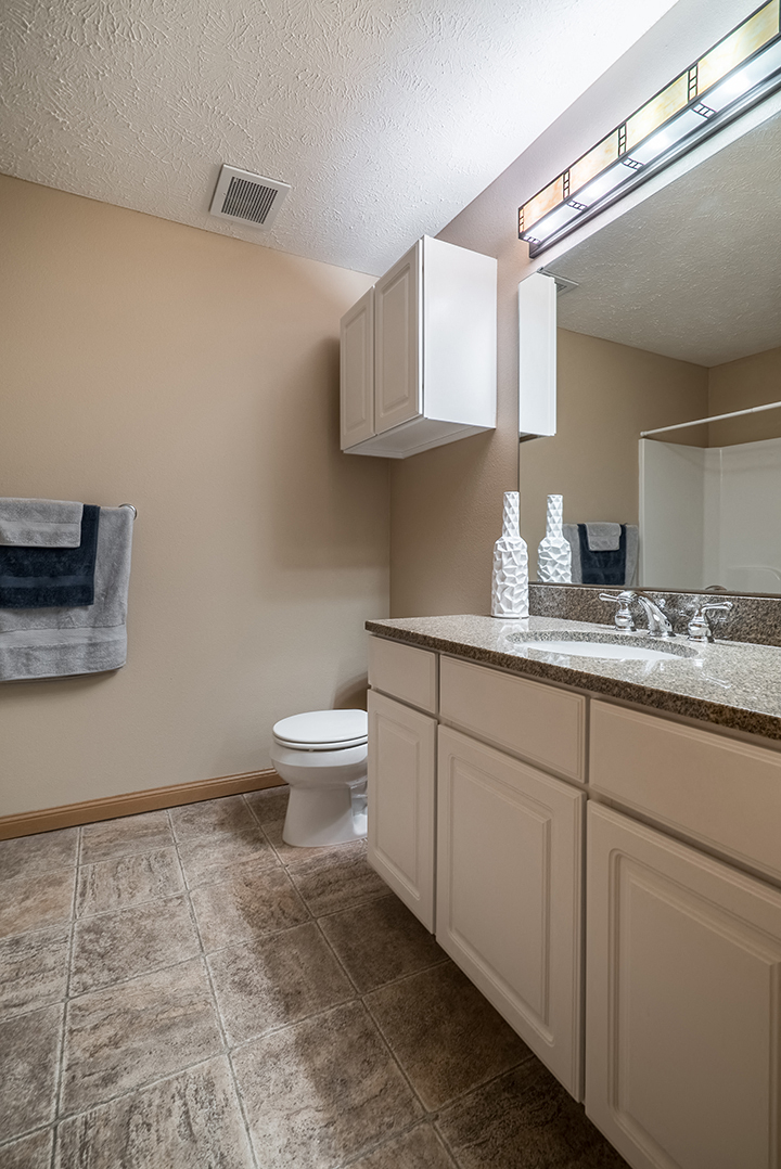 Brightly lit, spacious bathroom at Grand Legacy Apartments