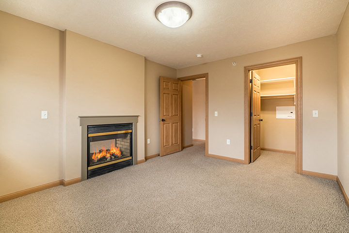 Large master bedroom with closet and fireplace at Grand Legacy Apartments