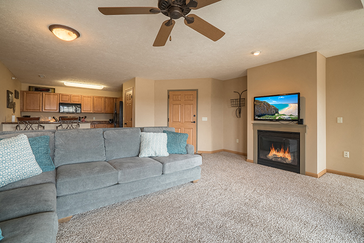 Large and bright living room with a fireplace for extra warmth at Grand Legacy Apartments