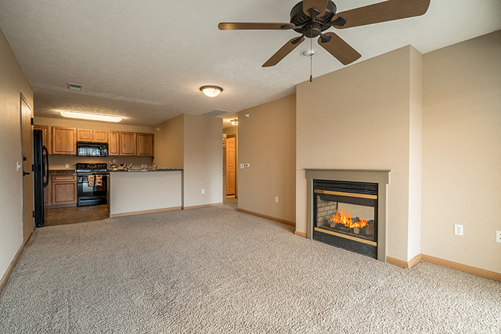 Large living space with fireplace and natural lighting at Grand Legacy Apartments