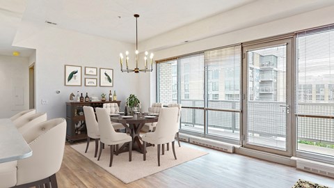 Enjoy the scenic views from the floor-to-ceiling windows in the dining and living area of a 2 bedroom penthouse floor plan at Midtown Crossing Apartments Omaha