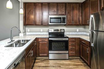 U-shaped kitchen with stainless steel appliances and white counters
