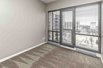 Bedroom with full-wall windows and carpeted floor