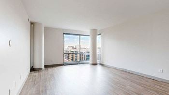 a spacious bright living area with large windows and wood-style flooring