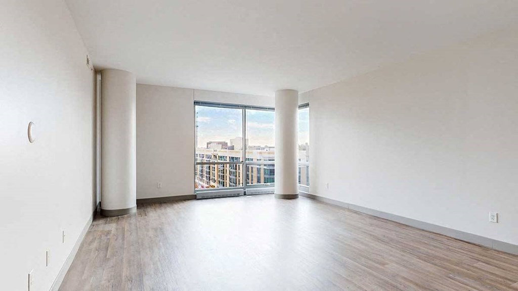 a spacious bright living area with large windows and wood-style flooring