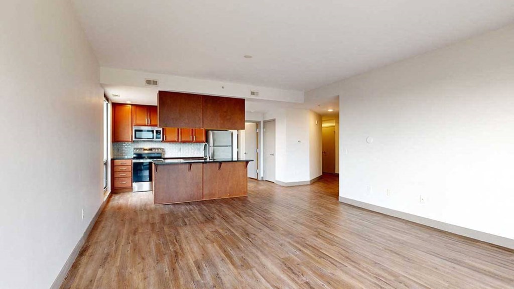 a kitchen and living room with wooden floors and white walls