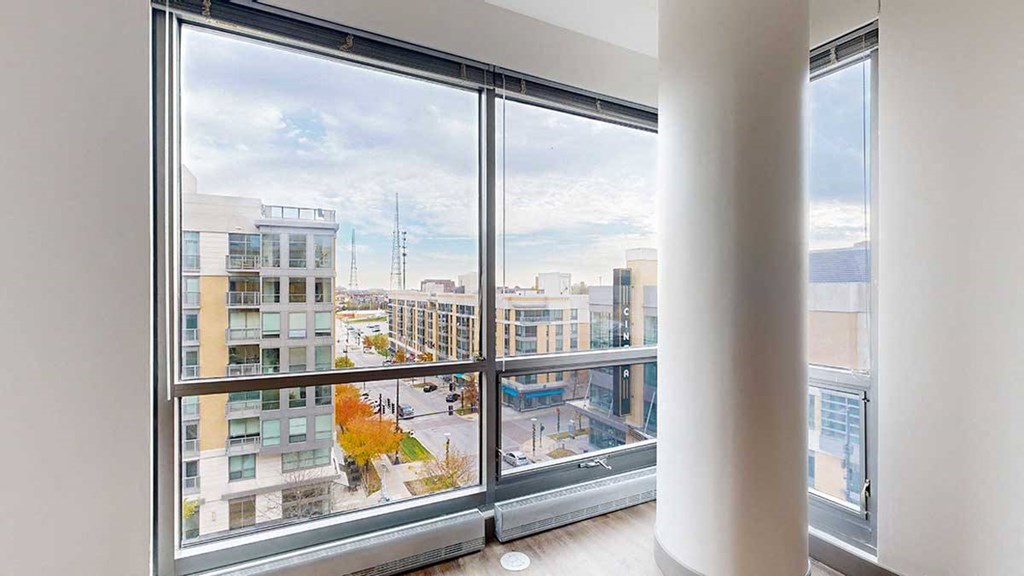 a floor to ceiling window with a view of midtown crossing from the living room of the 2-bedroom Tuscon