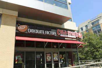 a cold stone creamery and chocolate factory storefront with a red awning