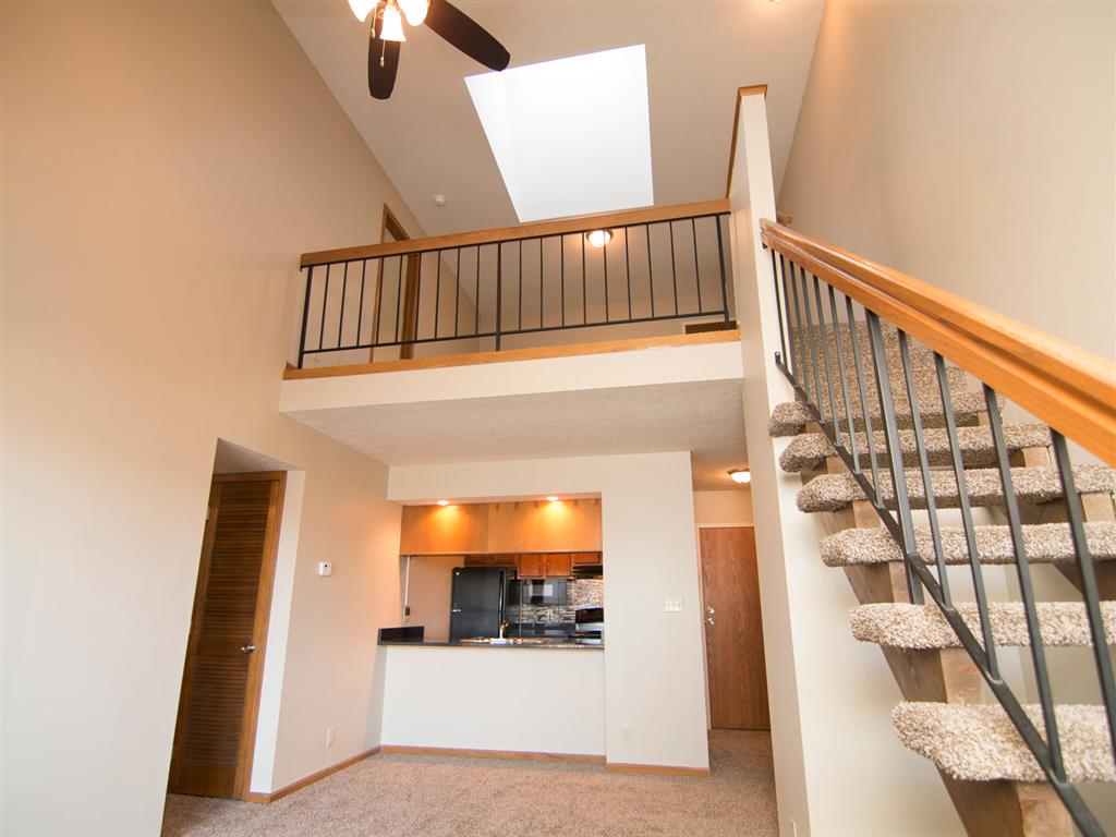 Kitchen and living room with view of stairs to the loft at Fountain Glen Apartments in Lincoln Nebraska