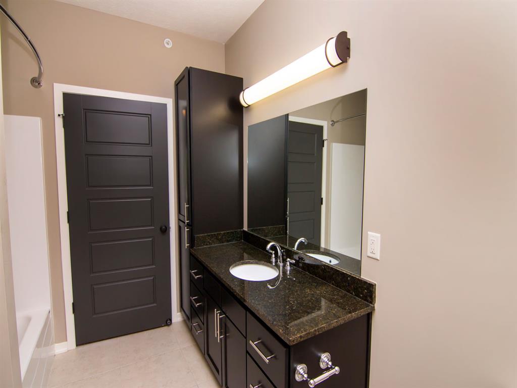 Bathroom with dark cabinets and a bathtub at North Pointe Villas