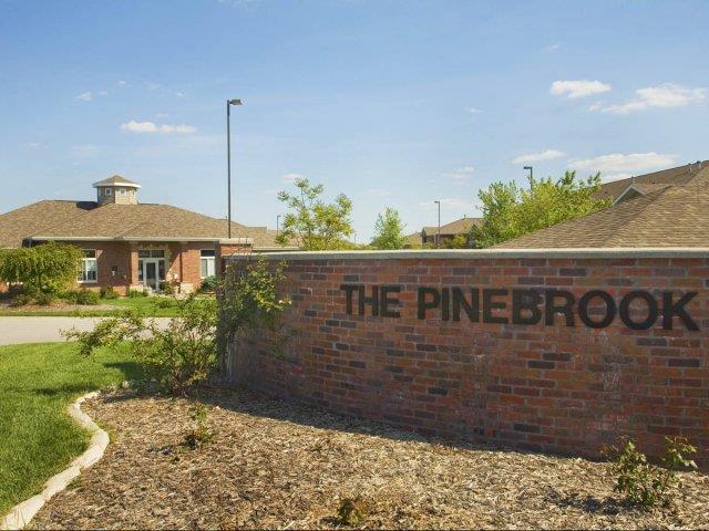 Exteriors-Pinebrook Apartments Sign and Clubhouse View in Lincoln NE