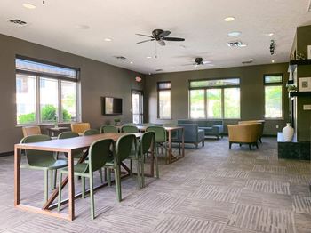 a conference room with tables and chairs and a ceiling fan