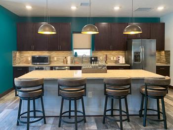 a kitchen with a large island with four bar stools