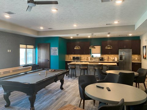 a game room with a pool table and a bar